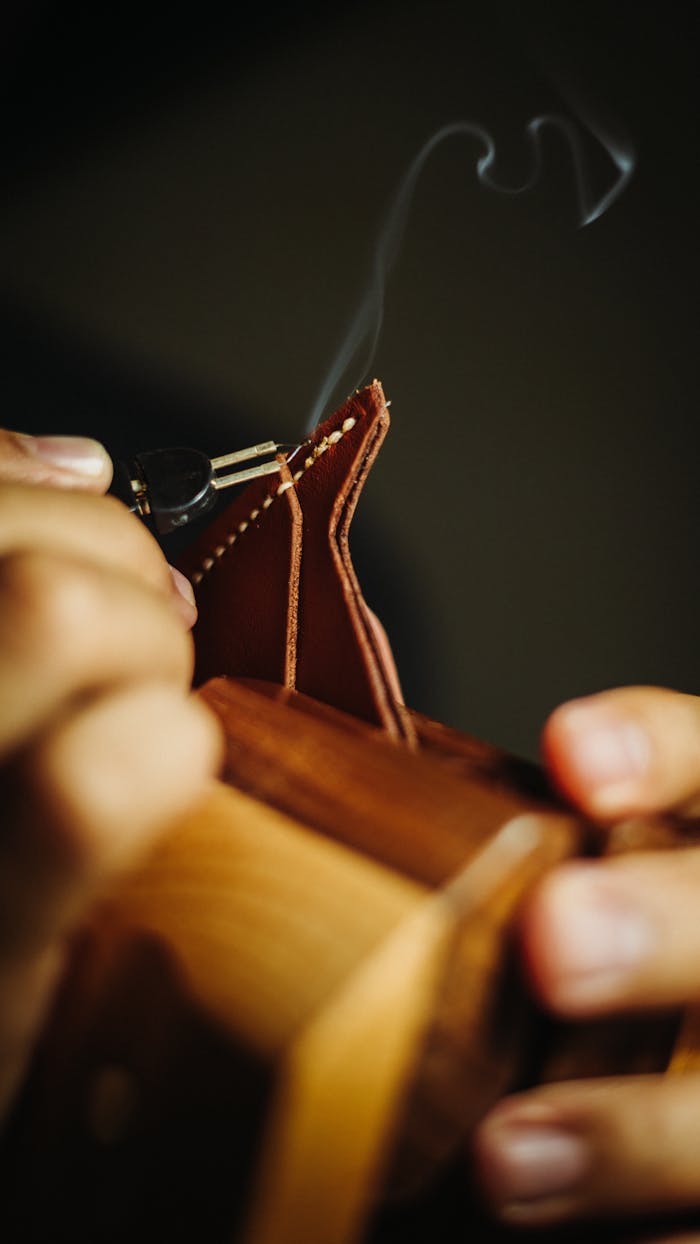 The Art of Drawing Readers In: Your attractive post title goes here Detailed view of a craftsman using a burner on leather for handcrafted wallet making.